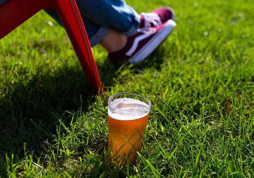 glass of beer in grass by woman's lawn chair at mother's brewery springfield mo