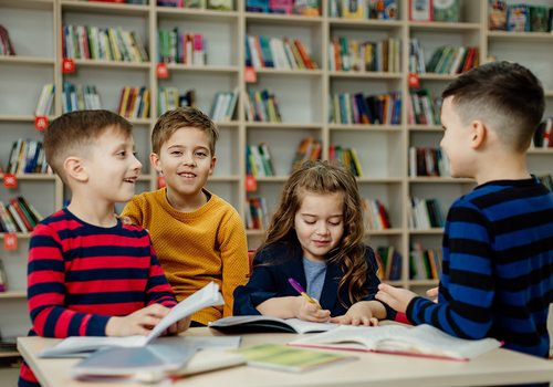 Kids reading and working around a table