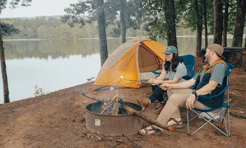 young couple roasting marshmallows over a campfire
